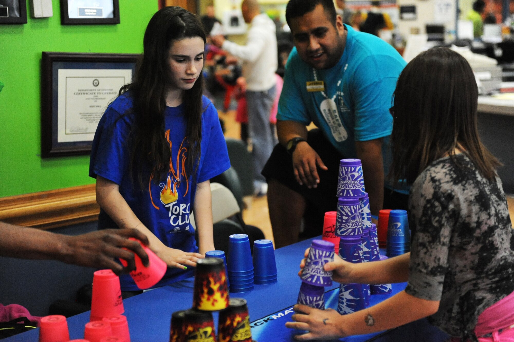 Alexandria Waller, a volunteer for the Youth Fair, competes against a participant in Sport Stacking at the Youth Center April 27. The Youth Center held the Youth Fair in light of the Month of the Military Child. The Month of the Military Child was created to recognize the contribution that the military child makes as their parent or parents serve our nation. The Youth Fair also had other activities such as a 4-H Skill-a-thon, basketball tournament and petting zoo. (U.S. Air Force photo/Senior Airman Jake Eckhardt)
