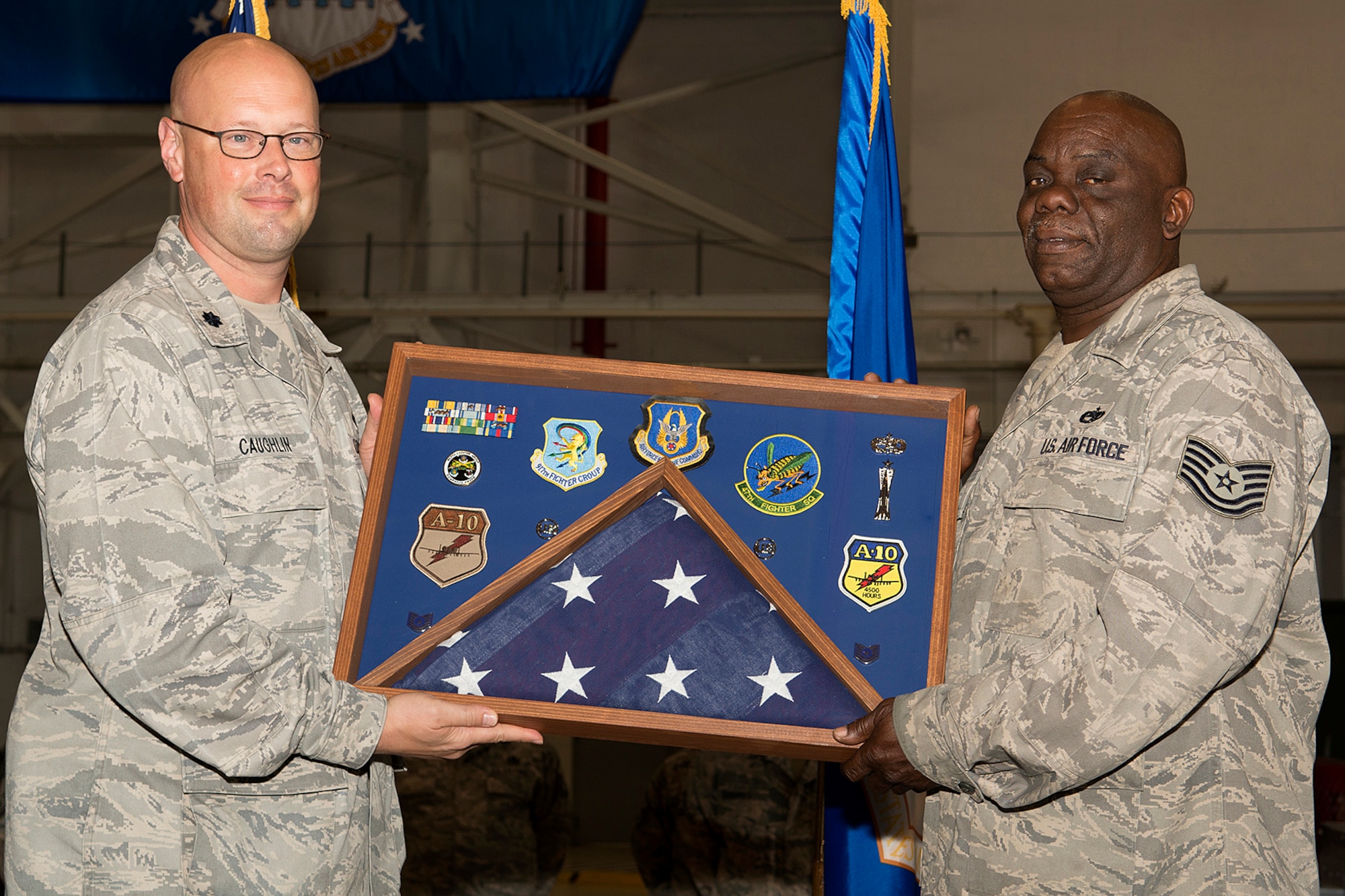 U.S. Air Force Lt. Col. Travis Caughlin, 917th Fighter Group deputy commander of maintenance, presents a career shadow box to Tech. Sgt. Bobby Duncan during a retirement ceremony, April 28, 2013, Barksdale Air Force Base, La. Duncan is retiring from the Air Force Reserve after 36 years of service. (U.S. Air Force photo by Master Sgt. Greg Steele/Released)