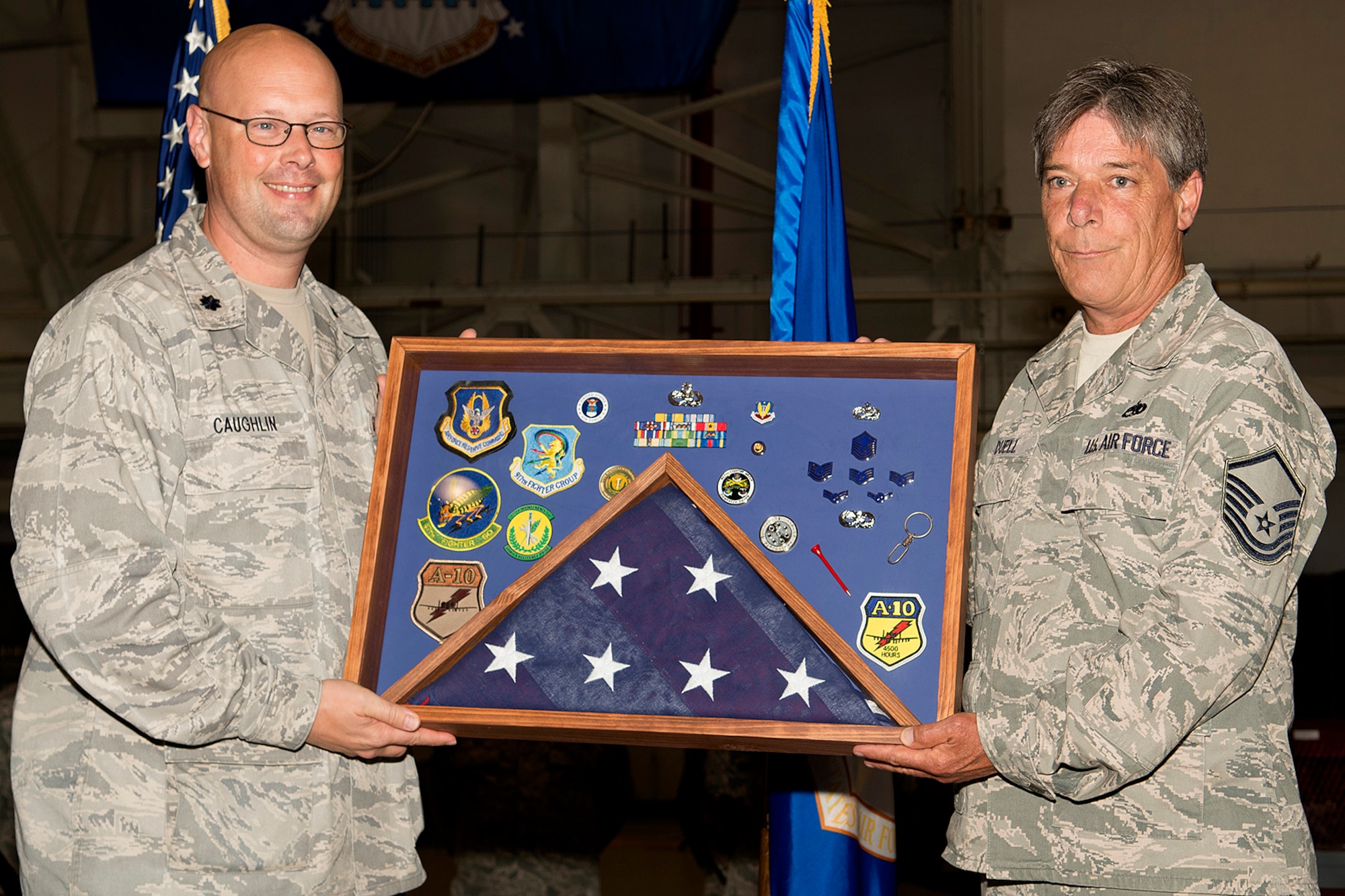 U.S. Air Force Lt. Col. Travis Caughlin, 917th Fighter Group deputy commander of maintenance, presents a career shadow box to Master Sgt. Mike Duell during a retirement ceremony, April 28, 2013, Barksdale Air Force Base, La. Duell is retiring from the Air Force Reserve with over 30 years of service. (U.S. Air Force photo by Master Sgt. Greg Steele/Released)