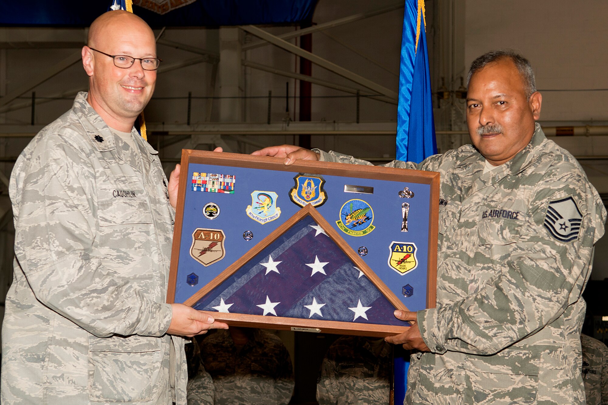 U.S. Air Force Lt. Col. Travis Caughlin, 917th Fighter Group deputy commander of maintenance, presents a career shadow box to Master Sgt. Jose Limon during a retirement ceremony, April 28, 2013, Barksdale Air Force Base, La. Limon is retiring from the Air Force Reserve after 35 years of service. (U.S. Air Force photo by Master Sgt. Greg Steele/Released)