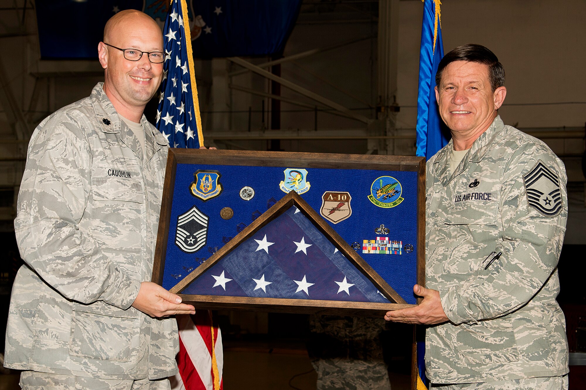 U.S. Air Force Lt. Col. Travis Caughlin, 917th Fighter Group deputy commander of maintenance, presents a career shadow box to Chief Master Sgt. Jimmy Wilcher during a retirement ceremony, April 28, 2013, Barksdale Air Force Base, La. Wilcher is retiring from the Air Force Reserve after 34 years of service. (U.S. Air Force photo by Master Sgt. Greg Steele/Released)