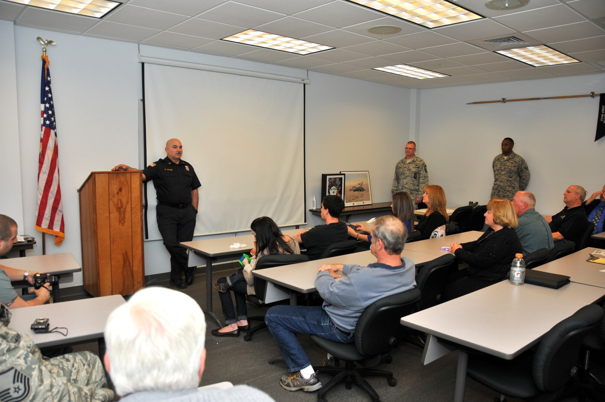 A picture of Chief Master Sgt. Dominick Galione speaking to a group of friends and family upon his retirement.