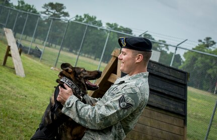 Staff Sgt. Kyle Shaughnessy, 628th Security Forces Squadron military working dog handler, praises MWD Jaga, a 3-year-old German Shepherd Dog assigned to the 628th SFS at Joint Base Charleston, S.C., after she completed the MWD obstacle course April 27, 2013, at JB Charleston – Air Base. Military Working Dogs  perform multiple duties and training including obedience skills, obstacle courses and various training objectives, depending on their specialized skill.  (U.S. Air Force Photo / Airman 1st Class Tom Brading)