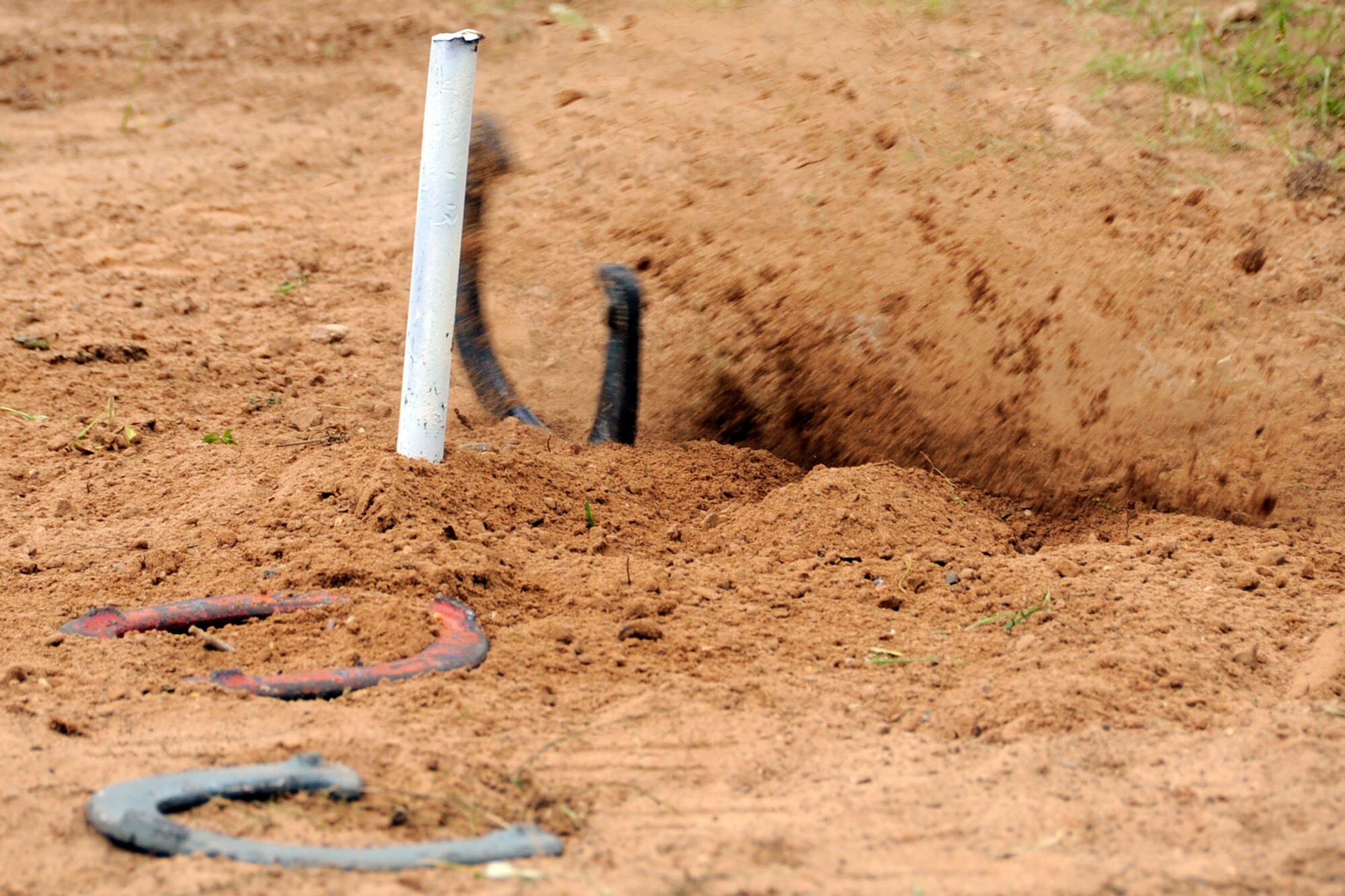 Close, but no ringer. A horseshoe thrown during a contest of skill, strikes close enough for points during the 307th Bomb Wing/917th Fighter Group Family Day at Cullen Park on Barksdale Air Force Base, La., April 28, 2012. The annual event is an opportunity for the reserve members and their families to get together for some fun and camaraderie. (U.S. Air Force photo by Master Sgt. Jeff Walston/Released)
