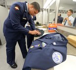 Air Force Junior Reserve Officer Training Corps Cadets Senior Airman Brian Newmuis (foreground), and Cadet Paris Wilson along with another unidentified cadet work on their uniform(s) and appearance before competing in the 2013 JROTC drill competition, April 20, 2013 at Dover Air Force Base, Del. The cadets are from William Penn High School, New Castle, Del.  (U.S. Air Force photo/Greg L. Davis)