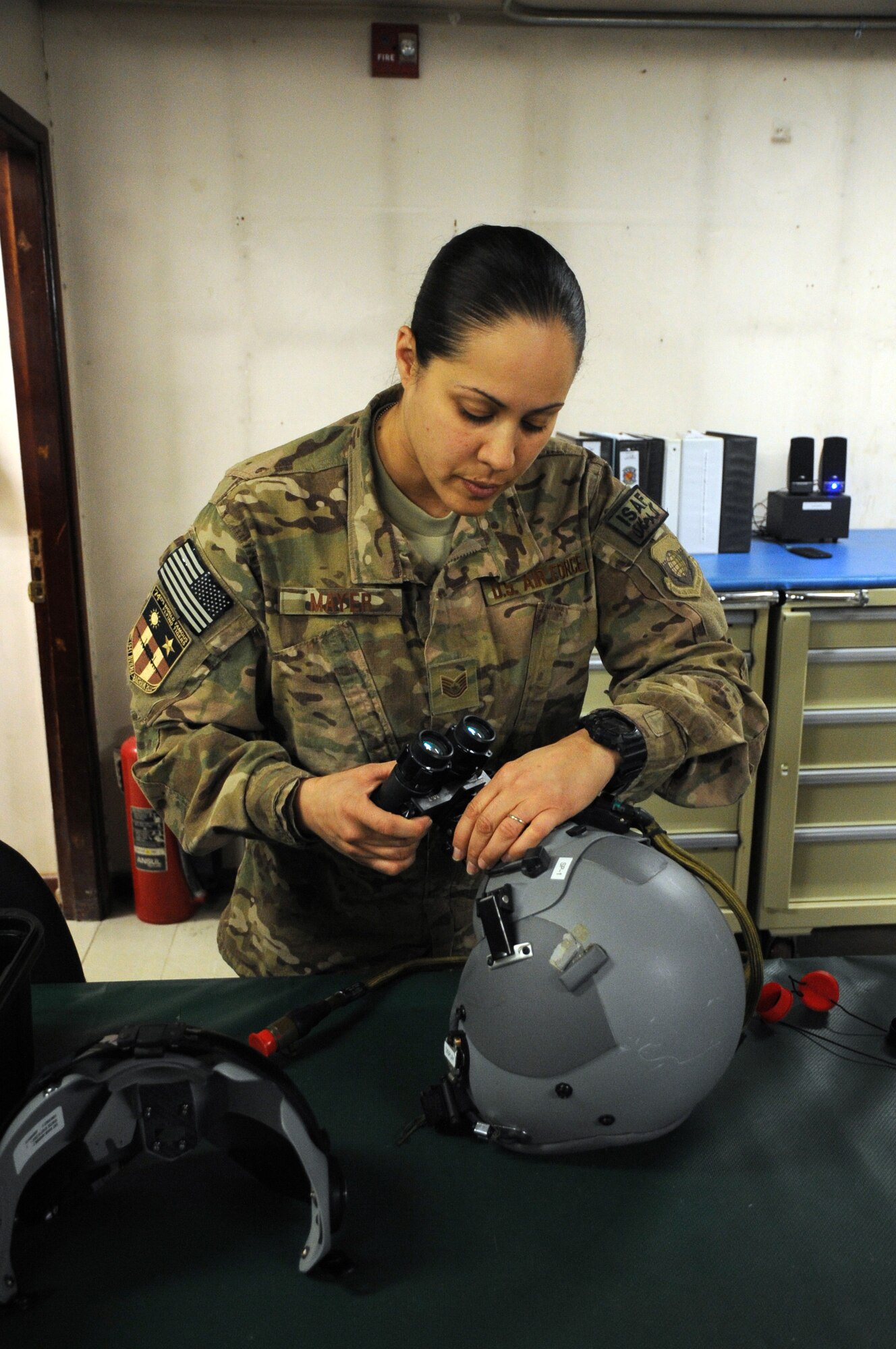 Tech. Sgt. Lissy Mayer, 74th Expeditionary Squadron NCO in charge of aircrew flight equipment deployed from Moody Air Force Base, Ga., makes adjustments to night-vision goggles on a pilot's helmet on Bagram Airfield, Afghanistan, April 29, 2013. The aircrew flight equipment section is manned 24 hours a day to ensure pilots' gear is ready prior to going out on missions. (U.S. Air Force photo/Staff Sgt. David Dobrydney)