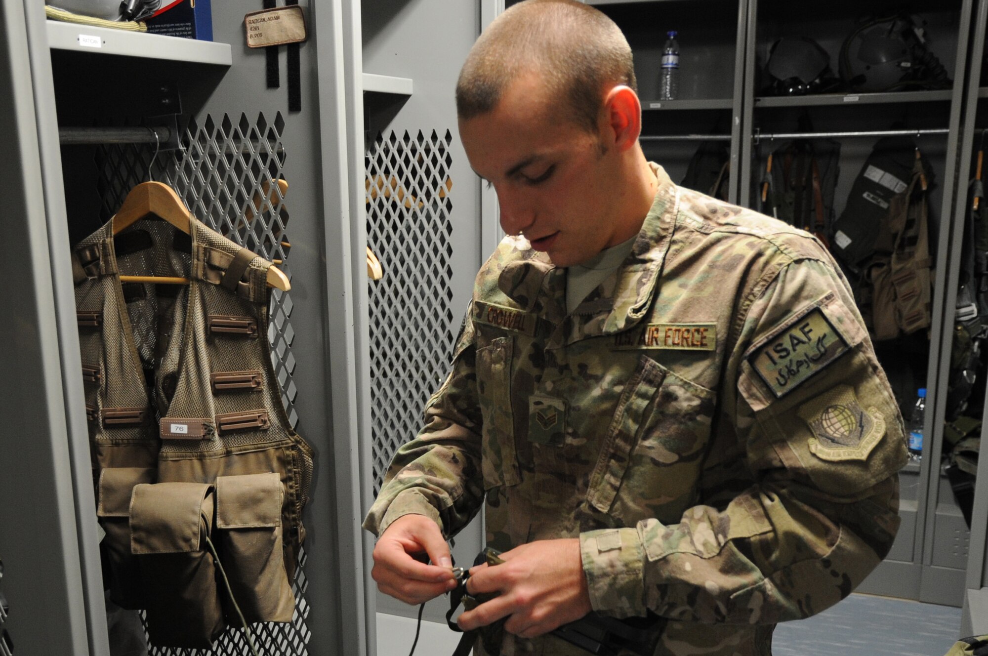 Senior Airman Sean Crowell, 74th Expeditionary Fighter Squadron aircrew flight equipment technician deployed from Moody Air Force Base, Ga., attaches a survival radio to a pilot's gear as part of pre-flight preparation on Bagram Airfield, Afghanistan, April 29, 2013. The aircrew flight equipment section is responsible for the proper function of all gear a pilot uses  when airborne. (U.S. Air Force photo/Staff Sgt. David Dobrydney)
