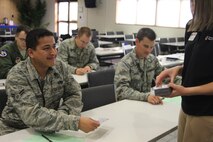 Lindsey Roegge, Kadena Red Cross marketing and publicity chair, passes 18th Medical Group magnets to newcomers during a newcomers' briefing on Kadena Air Base, Japan. The station recently procured about 1,000 magnets for the medical clinic's base newcomers' refrigerator magnet program. The program's goal is to provide quick reference, health-care related customer information for newly arriving active duty, family members and civilians. (Courtesy photo)