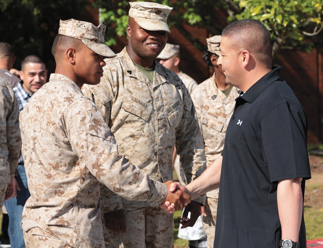 Lance Cpl. Peter A. Hernandez-Fuentes and Sgt. Derwent A. Vaughan welcome back Gunnery Sgt. Efrain Banuelos after his deployment to Afghanistan, here, April 23.