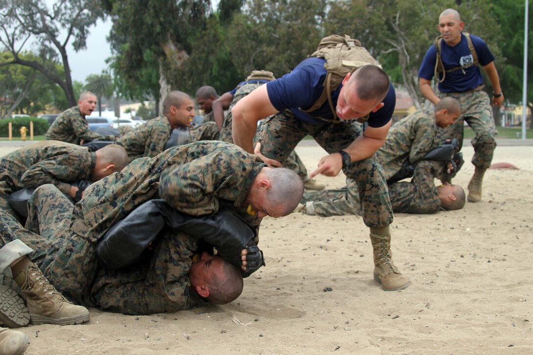 Sgt. Mark A. Peters, senior drill instructor, Company K, 3rd Recruit Training Battalion, encourages recruits to fight back during a combat conditioning exercise aboard Marine Corps Recruit Depot San Diego April 24. Recruits execute Marine Corps Martial Arts Program techniques while under a stressful environment to see how they perform.