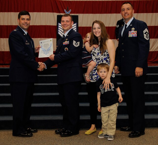Tech. Sgt. Travis Bowser, 2nd Force Support Squadron, receives a certificate of promotion to Tech. Sgt. from Col. Andrew Gebara, 2nd Bomb Wing Commander, during the May Wing Promotion Ceremony on Barksdale Air Force Base, La., May 1, 2013.