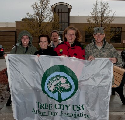Participants of McConnell’s annual Arbor Day celebration pose with a “Tree City USA” banner April 26, 2013, McConnell Air Force Base, Kan. McConnell AFB has been recognized as a “Tree City” for 19 consecutive years, a title given to communities that meet core standards of sound urban forestry management. (U.S. Air Force photo/Airman 1st Class Victor J. Caputo)
