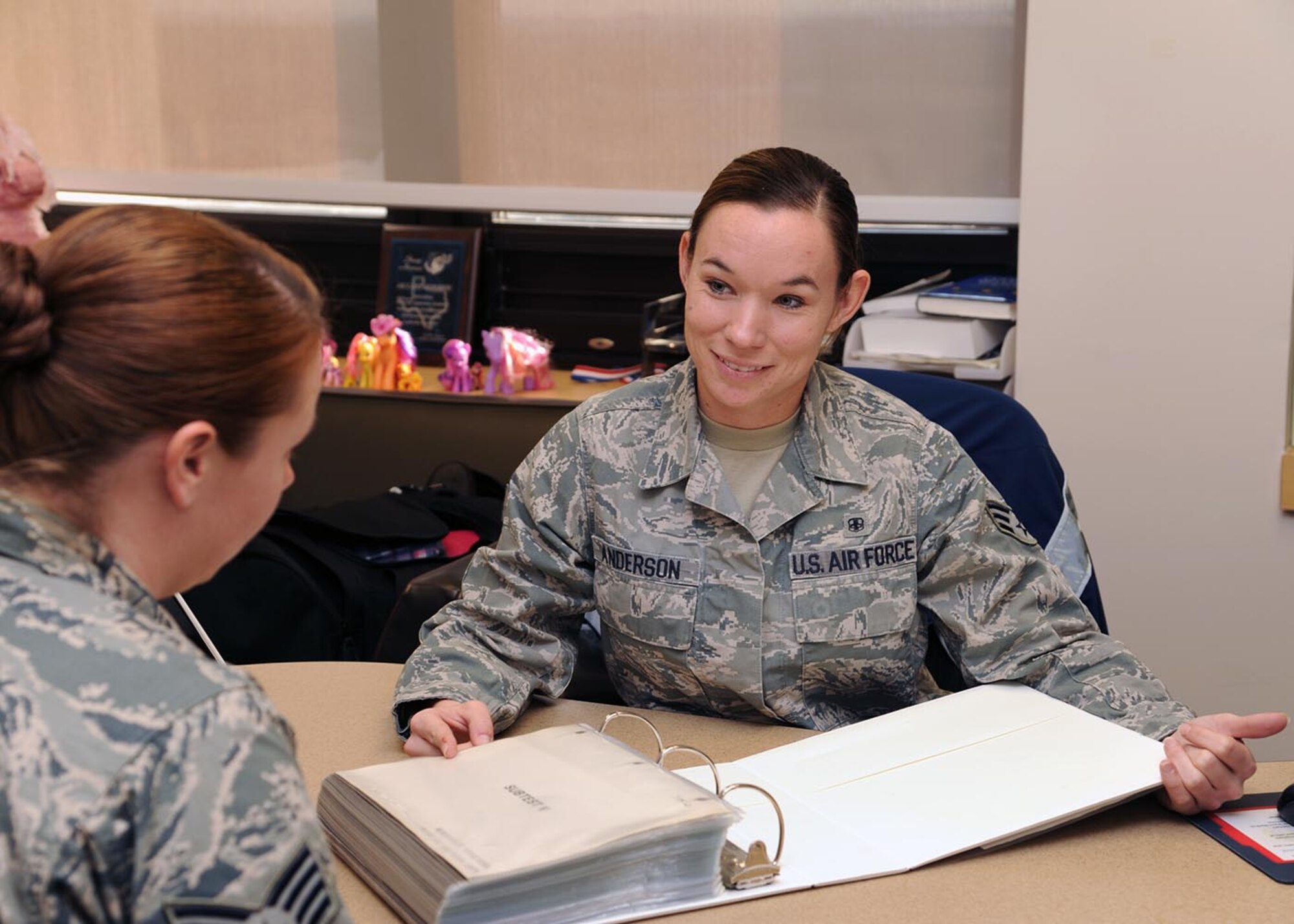 Senior Airman Casey Anderson discusses information with a mental health colleague at Wilford Hall Ambulatory Surgical Center, Joint Base San Antonio-Lackland, Texas. Anderson, a mental health/neuropsychology technician with the 59th Mental Health Squadron was recently selected as one of the Air Education and Training Command's 12 Outstanding Airmen of the Year. (U.S. Air Force photo/Senior Airman Courtney Moses)