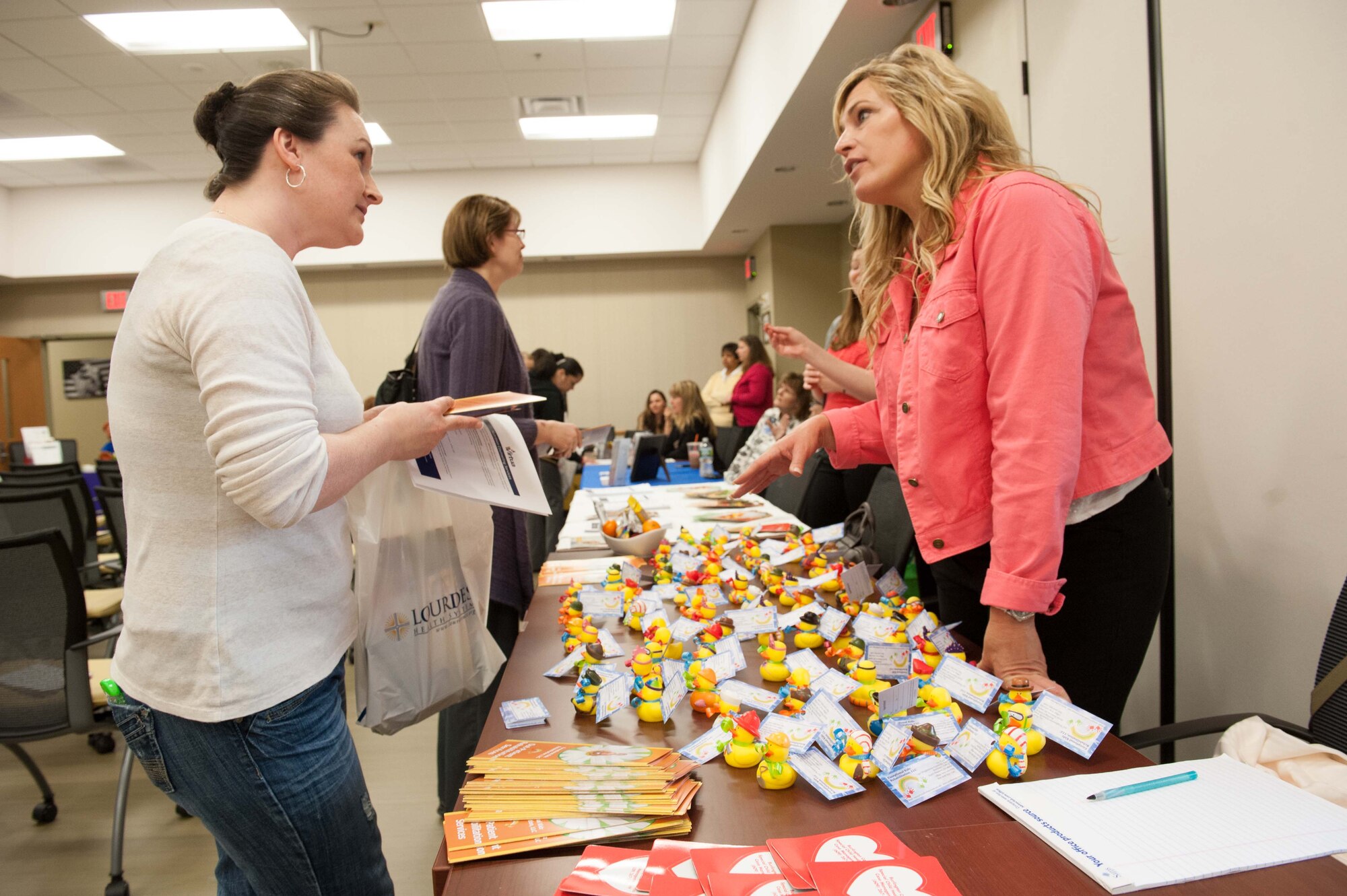 Katie Montez receives information from Monica LaSalle, owner of Exceptional Kidz Rehab, Philadelphia, at the Exceptional Family Member Program Spring Resource event April 17, 2013, at the Military and Family Support Center on Joint Base McGuire-Dix-Lakehurst, N.J. The event was part of the celebration for the Month of the Military Child and brought together military and civilian agencies to present information to help special needs families navigate through daily military life. Montez is the spouse of Tech. Sgt. Jesse Montez, U.S. Air Force Expeditionary Center K-9 instructor. (U.S. Air Force photo by Russ Meseroll/Released)
