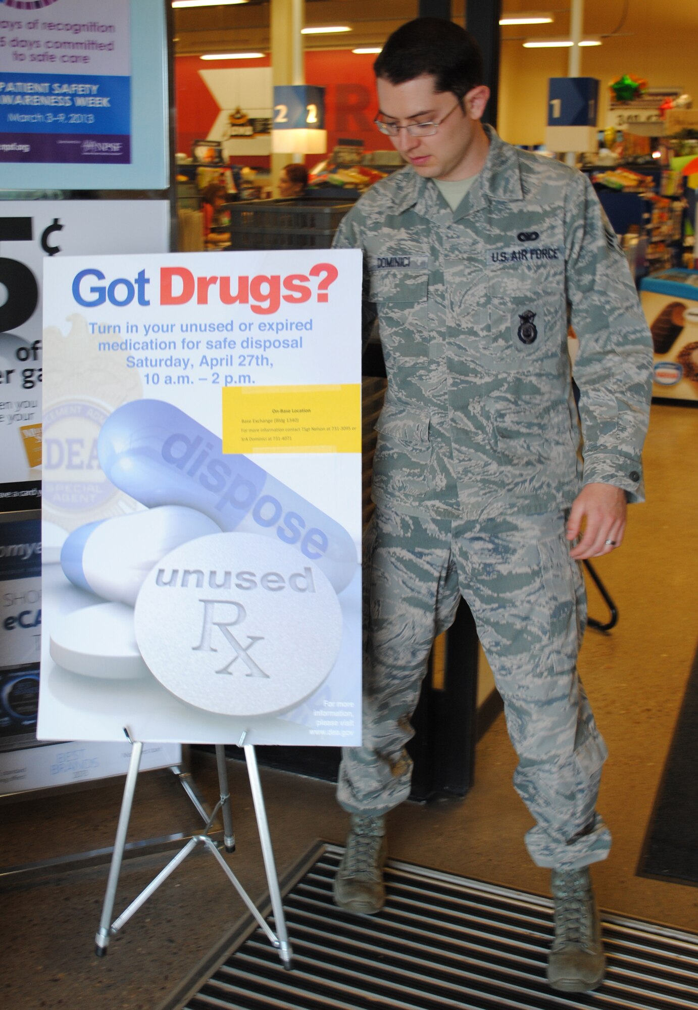 Senior Airman Jason Dominici, 341st Security Forces Squadron member, sets up a sign for Prescription Take-Back Day on April 27.  Team Malmstrom members were able to drop off unused prescription medications at the Base Exchange during the event.  (U.S. Air Force photo/Senior Airman Cortney Paxton) 