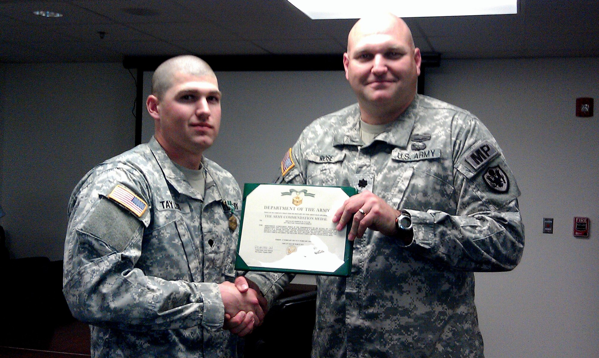 U.S. Army Spc. Derrek Taylor, left, a 221st Military Police Detachment patrolman, receives an Army Commendation Medal for his tip that led detectives to solve a $16,000 copper theft case at Fort Eustis, Va. April 9, 2013. Taylor said his situational awareness was a result of his military and police training. (Courtesy Photo)