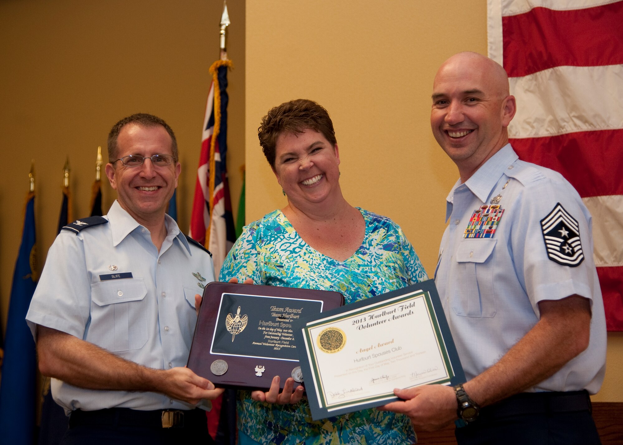 Col. Jim Slife, commander of 1st Special Operations Wing, left, and Chief Master Sgt. Jeffrey Maberry, command chief of 1st SOW, right, present Patsy Gordey, Hurlburt Spouses Club, center, with the team Angel Award during the annual Volunteer Recognition Ceremony at the Soundside Club at Hurlburt Field, Fla., May 1, 2013. The ceremony recognized 50 individuals and organizations for volunteerism in the Team Hurlburt and Emerald Coast communities in 2012. (U.S. Air Force photo / Airman 1st Class Nigel Sandridge) 