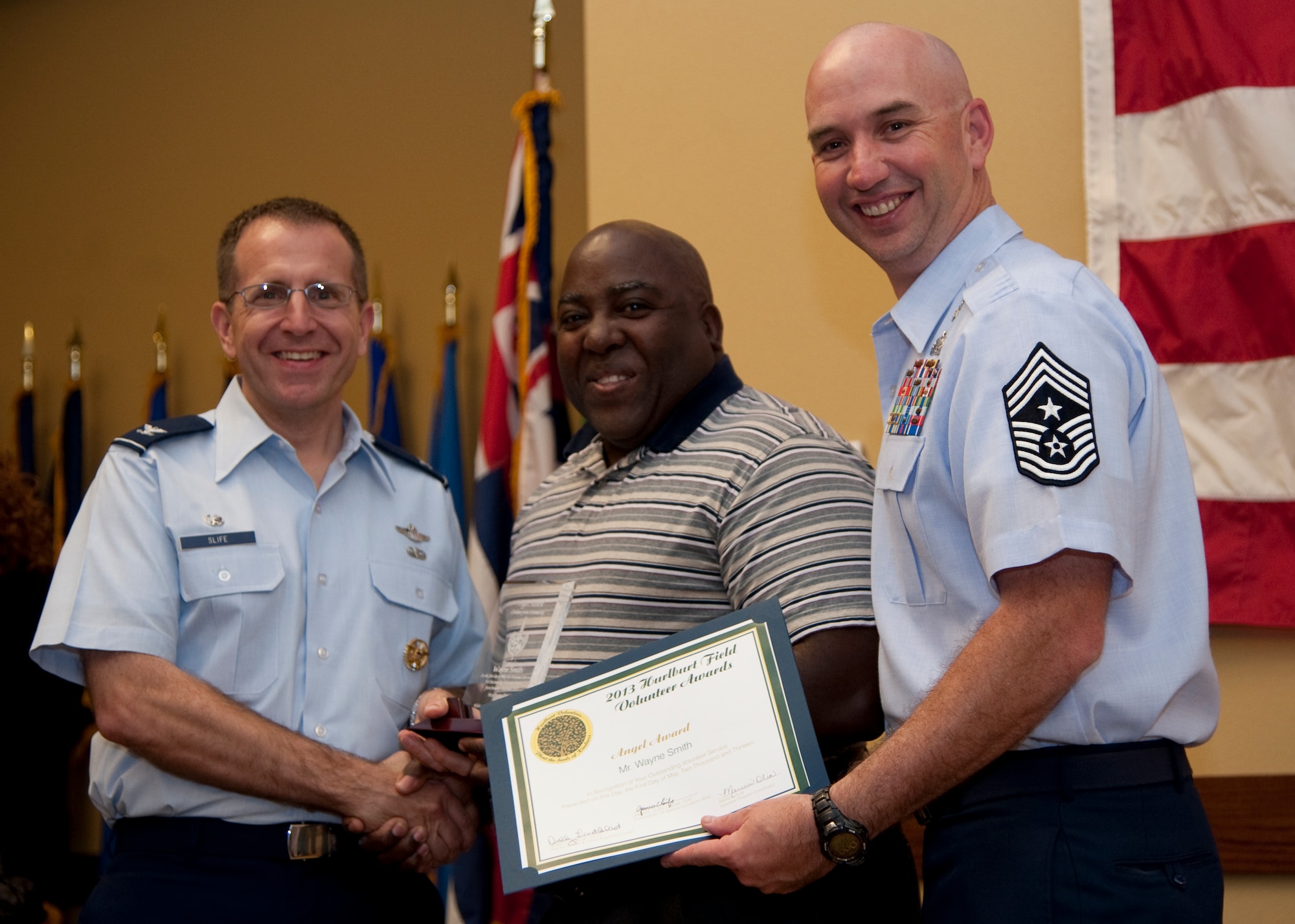 Col. Jim Slife, commander of 1st Special Operations Wing, left, and Chief Master Sgt. Jeffrey Maberry, command chief of 1st SOW, right, present Wayne Smith, Hurlburt Tax Office, center, with the civilian from the community Angel Award during the annual Volunteer Recognition Ceremony at the Soundside Club at Hurlburt Field, Fla., May 1, 2013. The ceremony recognized 50 individuals and organizations for volunteerism in the Team Hurlburt and Emerald Coast communities in 2012. (U.S. Air Force photo / Airman 1st Class Nigel Sandridge) 