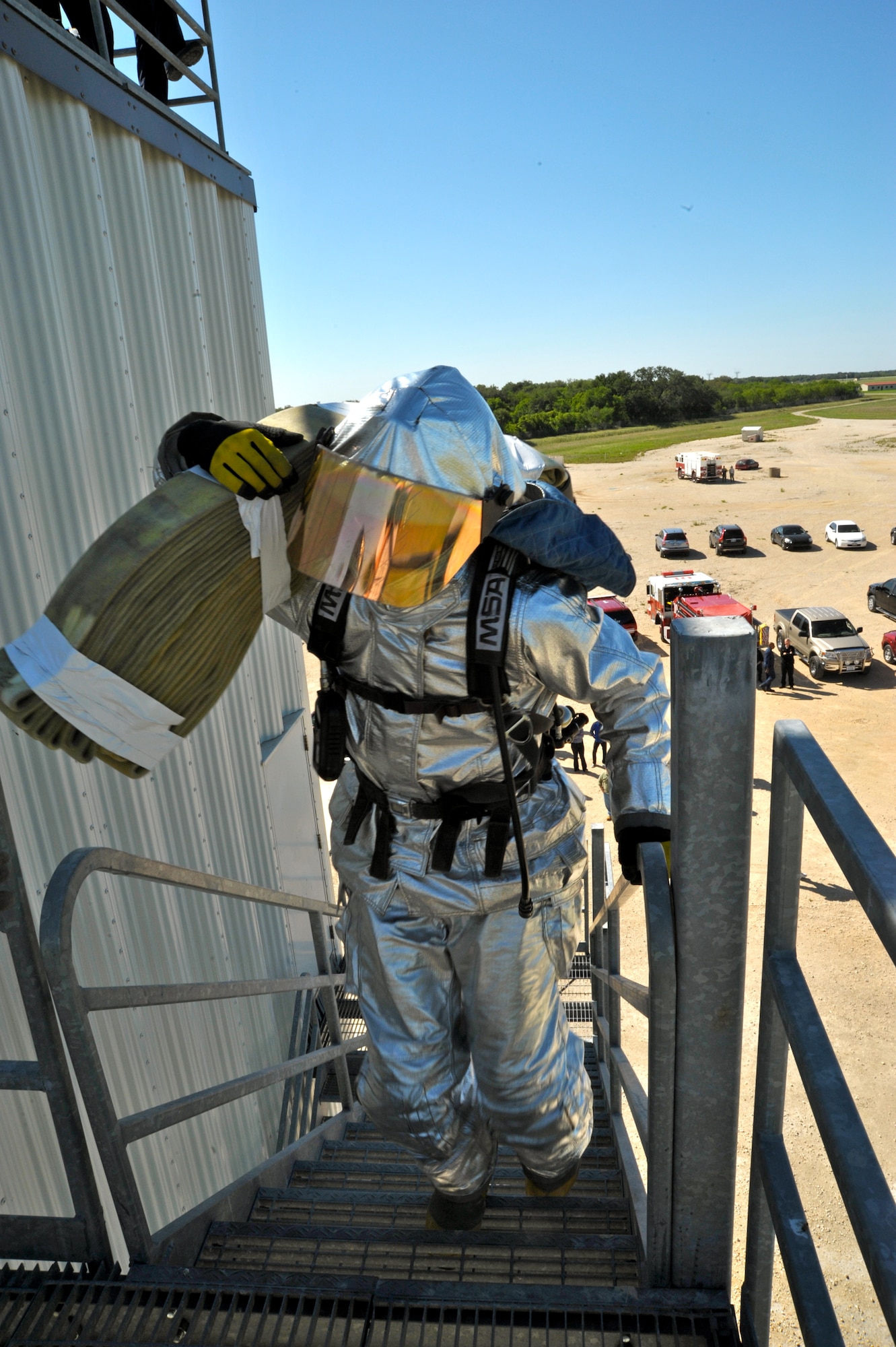 As a part of the firefighter challenge, one person from each team carried a three-inch hose up a set of staircases in order for his team to move onto the next portion of the relay event. (U.S. Air Force photo by Airman 1st Class Lincoln Korver/ Released)