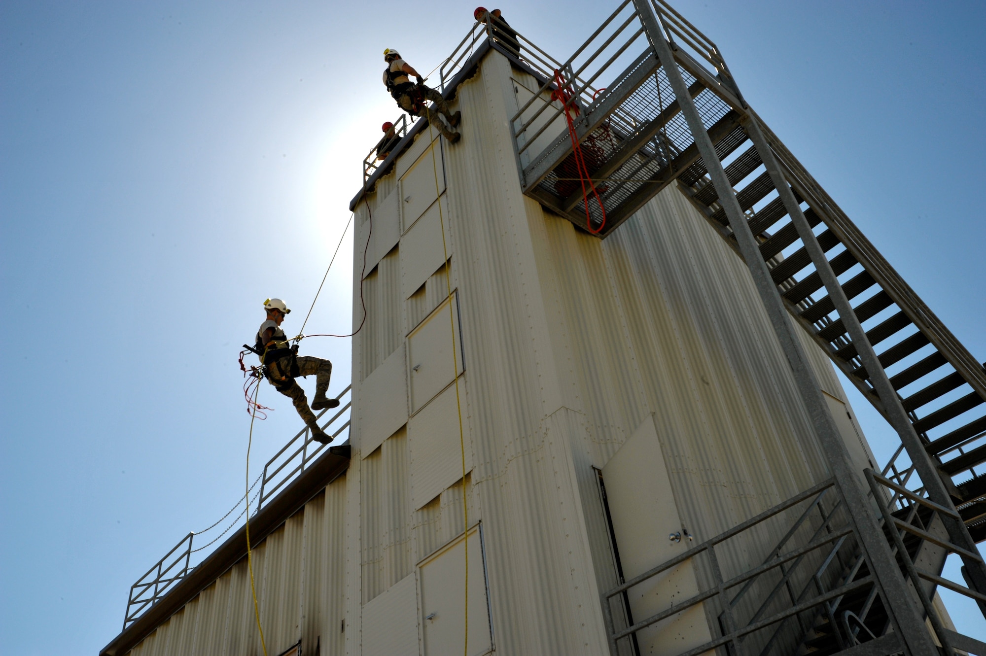 Air Force Staff Sgt. William Everett (lower left) and Airman 1st Class John Evans (upper right), 902nd Civil Engineer Squadron firefighters, demonstrate rappelling techniques at the annual JBSA-Randolph Battle of the Badges competition April 20. (U.S. Air Force photo by Airman 1st Class Lincoln Korver/ Released)