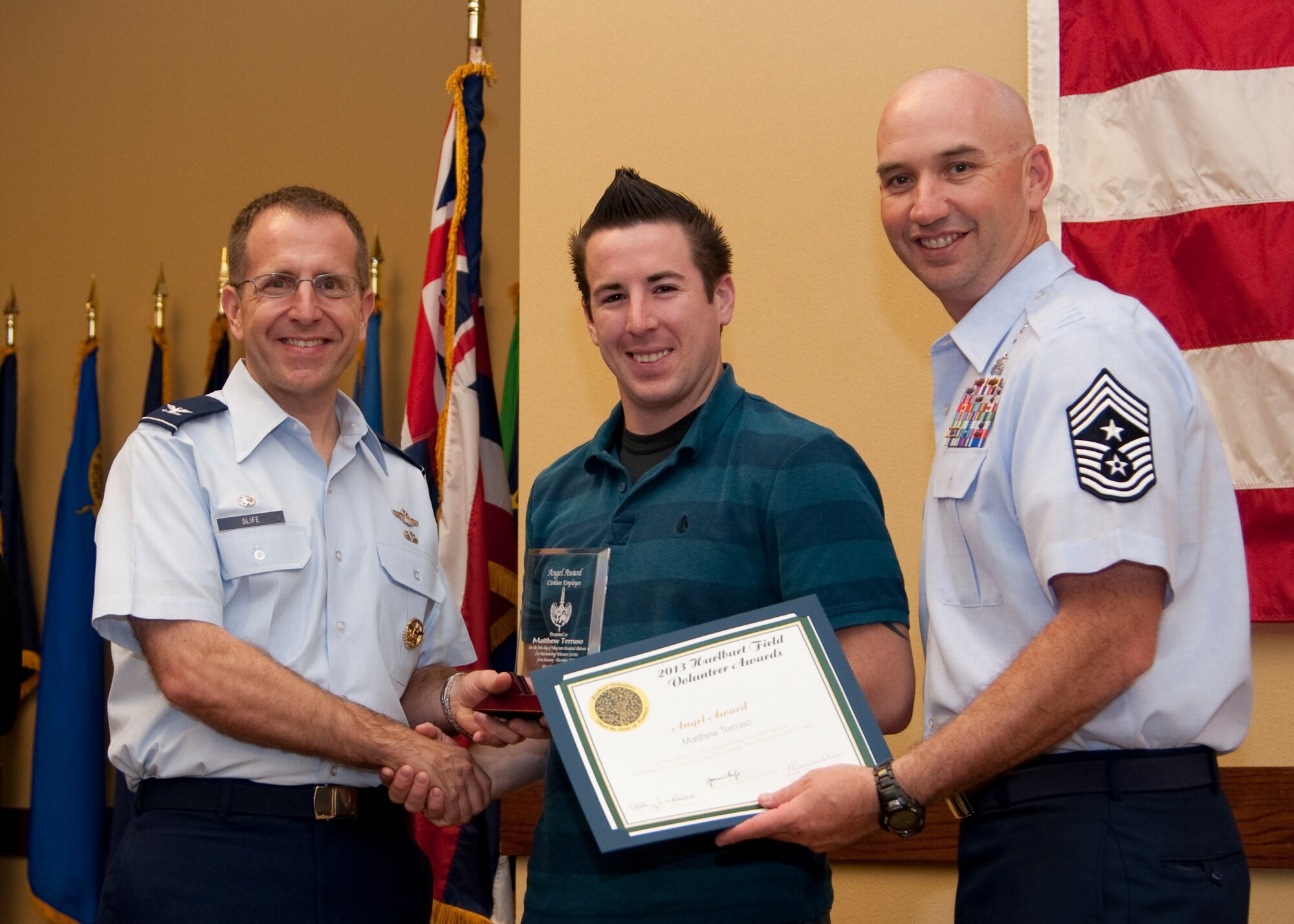 Col. Jim Slife, commander of 1st Special Operations Wing, left, and Chief Master Sgt. Jeffrey Maberry, command chief of 1st SOW, right, present Matthew Terruso, 1st Special Operations Force Support Squadron, center, with the civilan employee Angel Award during the annual Volunteer Recognition Ceremony at the Soundside Club at Hurlburt Field, Fla., May 1, 2013. The ceremony recognized 50 individuals and organizations for volunteerism in the Team Hurlburt and Emerald Coast communities in 2012. (U.S. Air Force photo / Airman 1st Class Nigel Sandridge) 