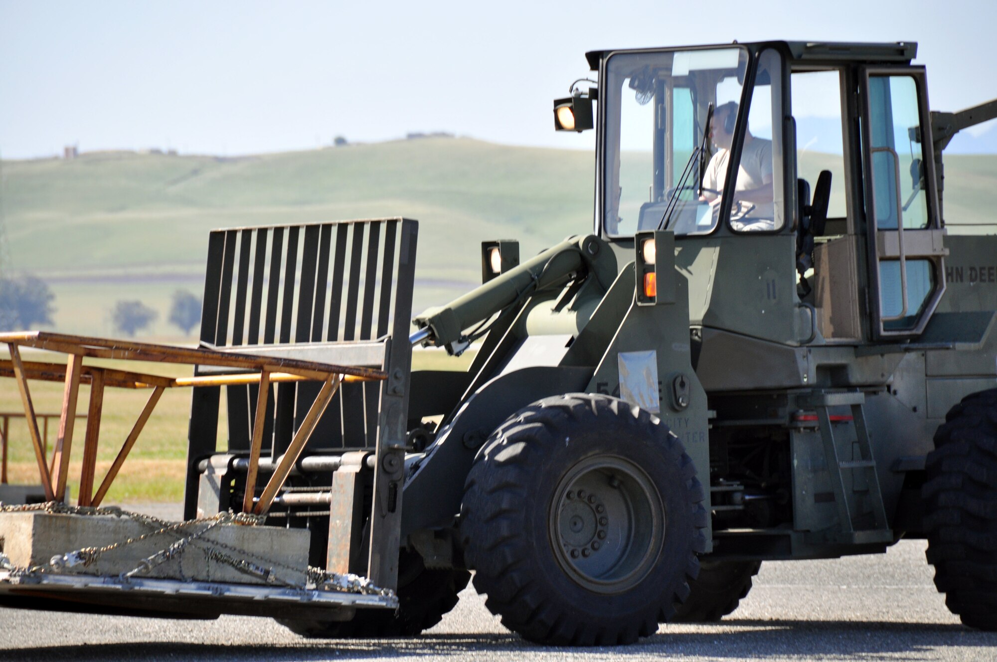 TRAVIS AIR FORCE BASE, Calif. --Staff Sgt. Andrew Bell, air terminal information controller with the 55th Aerial Port Squadron drives a fork-lift to move a cement block from one location of a course to the next. It was part of a friendly competition and training event between the 55th APS and the 82nd Aerial Port Squadron held on April 21, 2013. (U.S. Air Force photo / Senior Airman Cindy Alejandrez)