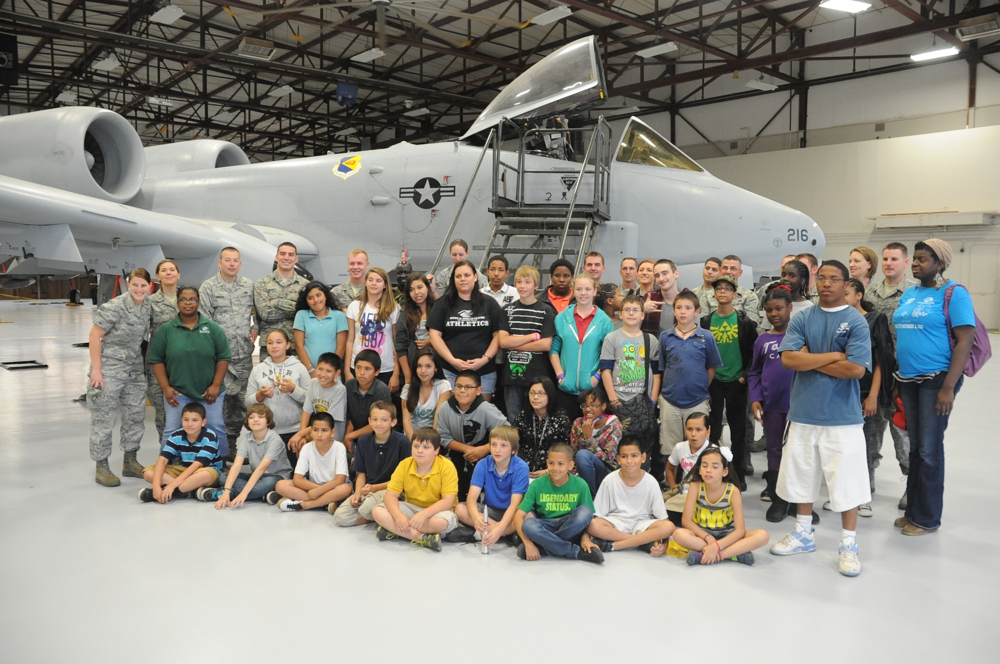 The Aircraft Maintenance Officer Course (AMOC), class 130211, and the Boys and Girls club of Wichita Falls stand in a maintenance hanger May 1 2013 at Sheppard Air Force Base. AMOC prepares officers to direct air shows and activities on the flight line. (U.S, Air Force photo by Airman 1st Class Jelani Gibson)  
