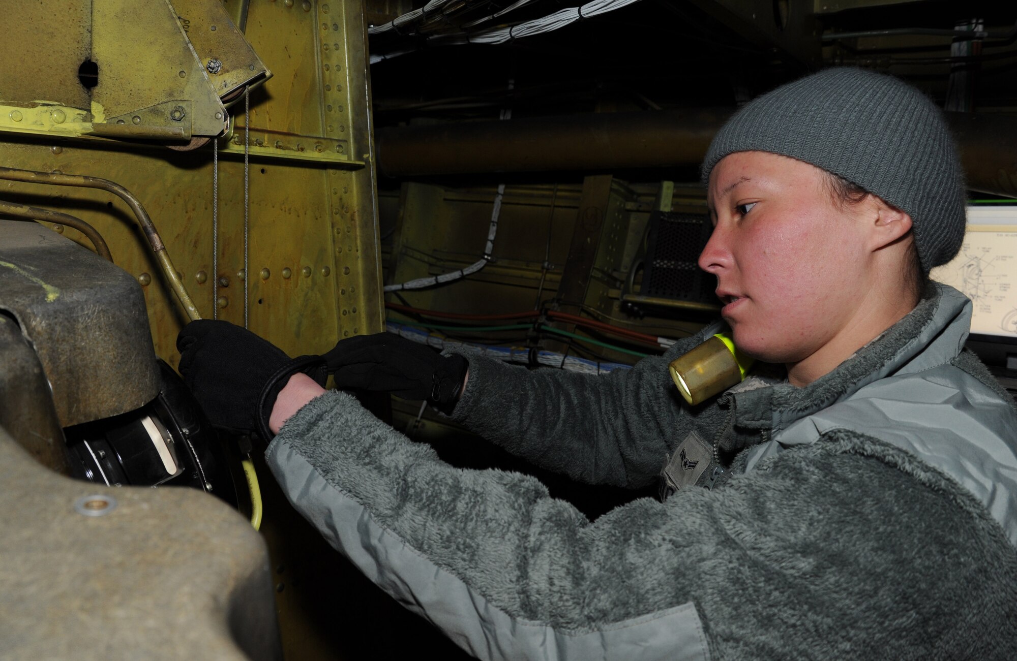 Airman 1st Class Charlotte Binkoski, 92nd Aircraft Maintenance Squadron electrical and environmental systems apprentice, removes the outflow valve to release cabin pressure in the lower nose of a KC-135 Stratotanker at Fairchild Air Force Base, Wash., May 1, 2013. Binkoski has been selected as a member of Fairchild’s Finest. (U.S. Air Force photo by Airman 1st Class Janelle Patiño/Released)