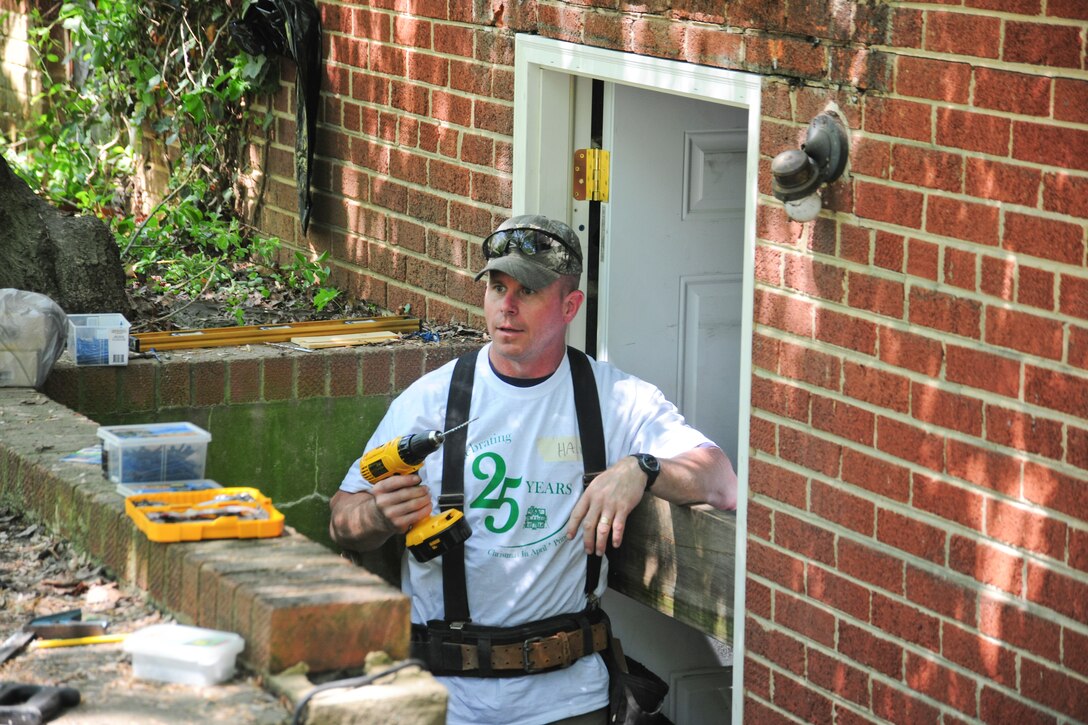 Joint Base Andrews, Md., Master Sgt. Michael Hall, 11th Force Support Squadron career assistance advisor, repairs the back entrance of a Christmas in April recipients home, April 27, 2013. Team Andrews members helped support the long-standing annual program fixing homes of low-income, disabled and elderly people. (U.S. Air Force photo/Staff Sgt. Amber Russell)