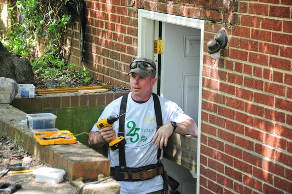 Joint Base Andrews, Md., Master Sgt. Michael Hall, 11th Force Support Squadron career assistance advisor, repairs the back entrance of a Christmas in April recipients home, April 27, 2013. Team Andrews members helped support the long-standing annual program fixing homes of low-income, disabled and elderly people. (U.S. Air Force photo/Staff Sgt. Amber Russell)