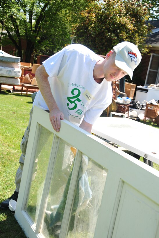 Joint Base Andrews, Md., Staff Sgt. Matthew Adams, 99th Airlift Squadron communications specialists operator, helps refurbish and paint doors, April 27, 2013, in a community effort to spruce up  homes of low-income, disabled and elderly people. Team Andrews members helped support the 25th Christmas in April event. (U.S. Air Force photo/Staff Sgt. Amber Russell)
