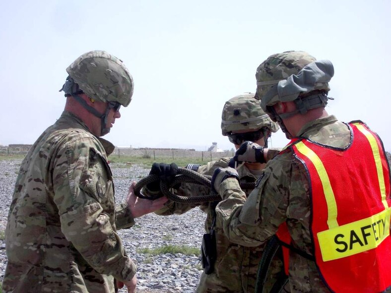 U.S. Air Force Tech. Sgt. Terry Beasley supervises the rigging of a slingleg with breakaway ties by U.S. Army Lt. Col. Erica Herzog and U.S. Air Force Senior Airman Joshua Foley during a coalition-joint slingload mission at Kandahar Airfield, Afghanistan. Beasley is deployed from Moody Air Force Base, Ga. (Courtesy photo)