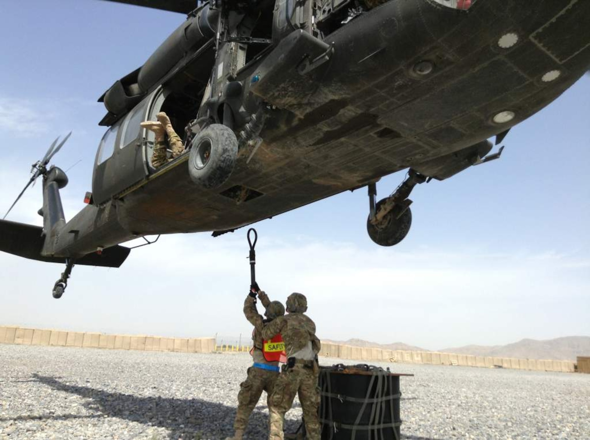 U.S. Air Force Staff Sgt. Shawn Beedham
and U.S. Air Force Senior Airman Joshua Foley, both from the 451st Expeditionary Logistics Readiness Squadron, prepare to hook an 1,800 pound A-22 cargo bag to a UH-60 Black Hawk flown by Soldiers of the 3rd Combat Aviation Brigade during a coalition-joint slingload mission at Kandahar Airfield, Afghanistan. (Courtesy photo)

