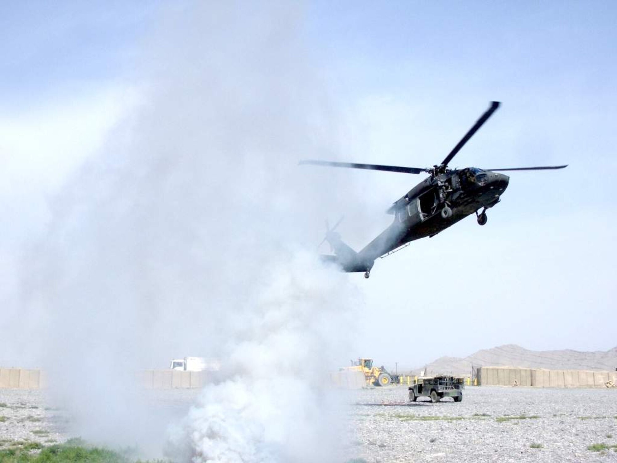Soldiers of the 3rd Combat Aviation Brigade follow a trail of signaling smoke into a landing zone on Kandahar Airfield, Afghanistan, during a coalition-joint slingload mission. (Courtesy photo)