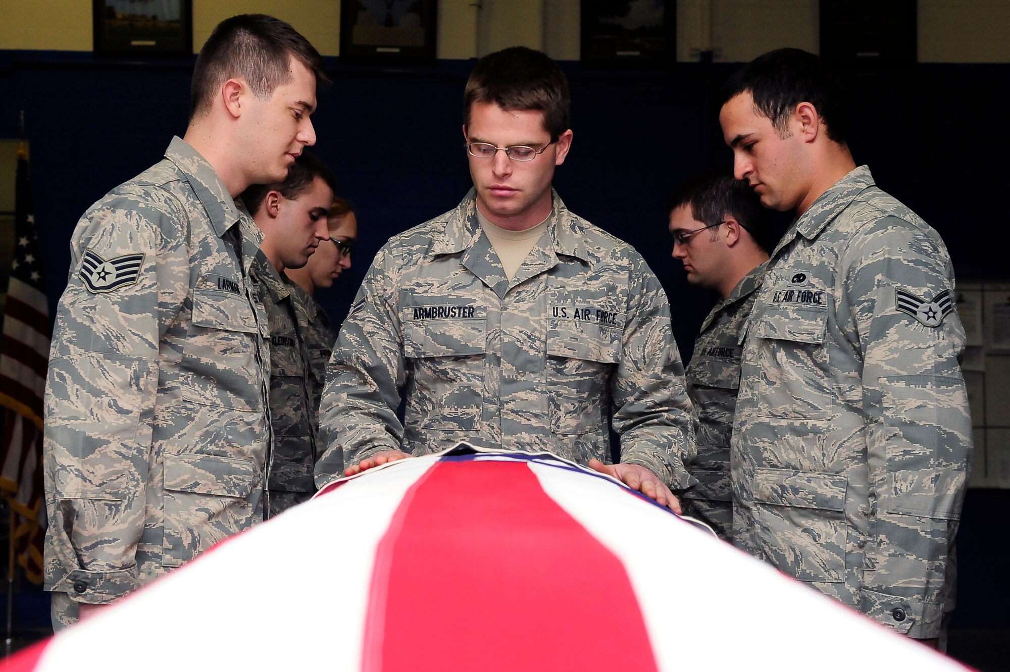 Airman 1st Class Nathaniel Armbruster, 509th Bomb Wing Honor Guard A-Team member, begins a seven-person flag fold at Whiteman Air Force Base, Mo., April 23, 2013. A team of seven Airmen perform funeral services for military retirees. (U.S. Air Force photo by Airman 1st Class Shelby R. Orozco/Released)