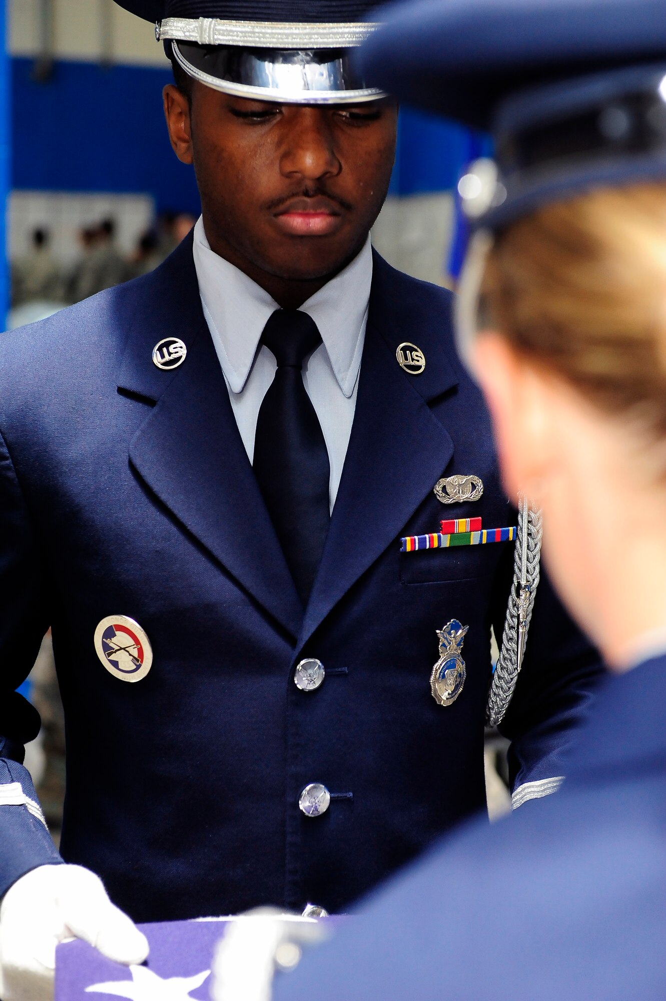 Senior Airman Chris Anderson and Senior Airman Julianne Pendergast, 509th Bomb Wing Honor Guard A-Team members, perform a two-person flag fold at Whiteman Air Force Base, Mo., April 23, 2013. Funeral services for military veterans are performed by a team of only two Airmen. (U.S. Air Force photo by Airman 1st Class Shelby R. Orozco/Released)
