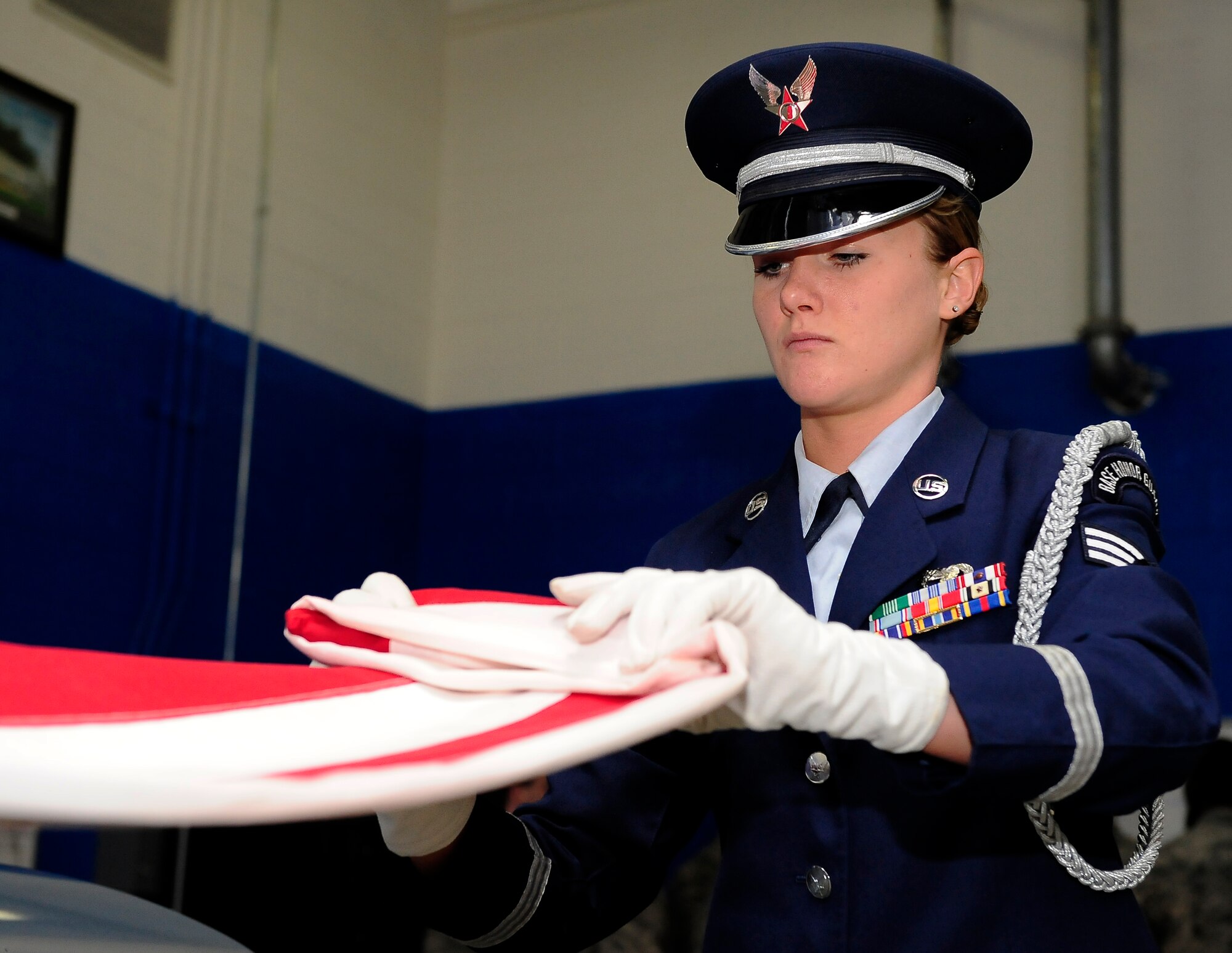 Senior Airman Julianne Pendergast, 509th Bomb Wing Honor Guard A-Team member, demonstrates a two-person flag fold at Whiteman Air Force Base, Mo., April 23, 2013. Outside of funerals, Whiteman’s Honor Guard also performs at sporting events and other key base functions. (U.S. Air Force photo by Airman 1st Class Shelby R. Orozco/Released)