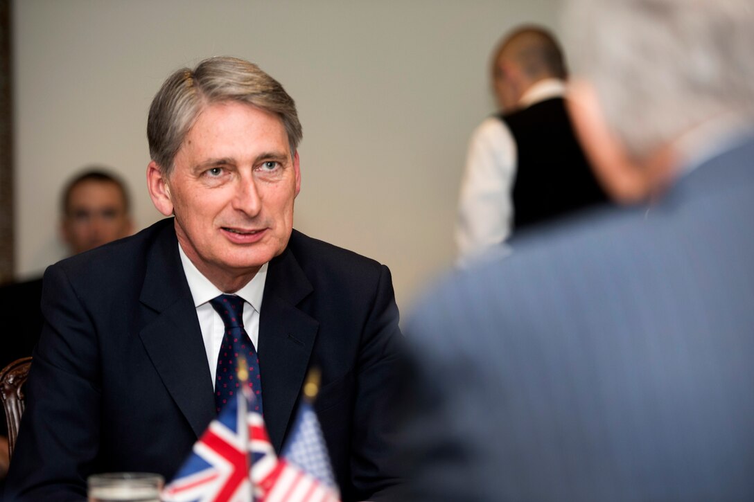 British Defense Secretary Philip Hammond, left, meets with U.S. Defense Secretary Chuck Hagel, foreground, at the Pentagon, May 2, 2013.