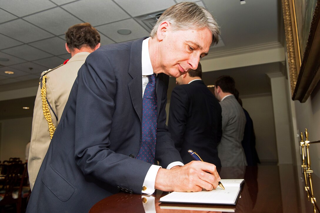British Defense Secretary Philip Hammond signs the guest book during a visit with U.S. Defense Secretary Chuck Hagel at the Pentagon, May 2, 2013. 
