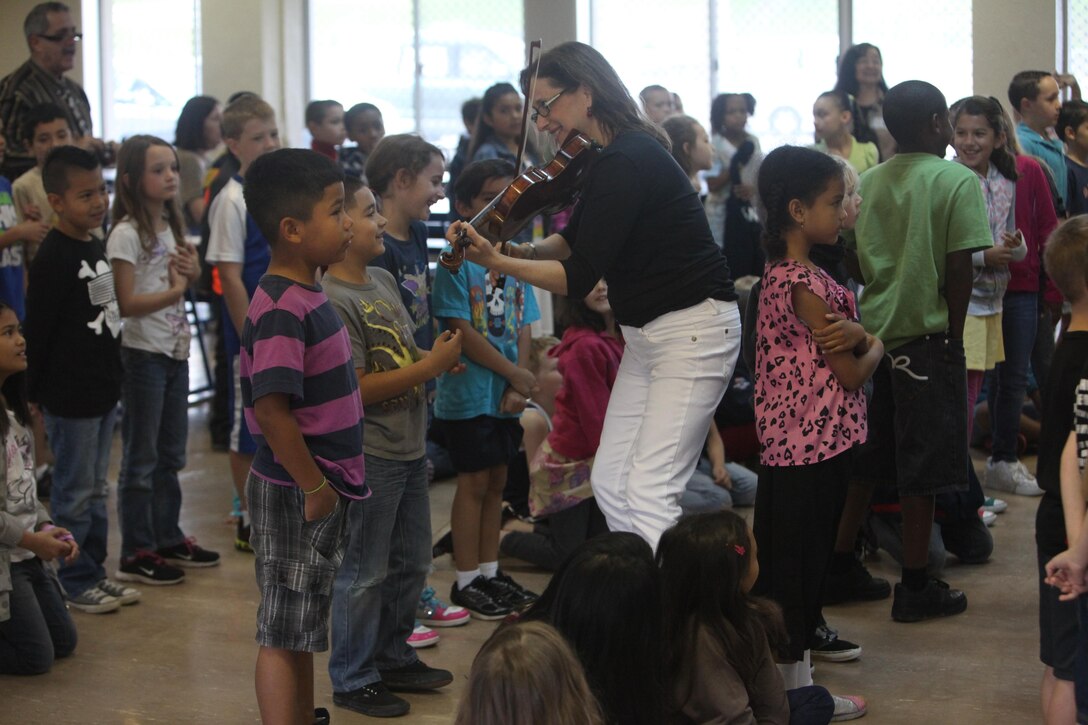 Debbie Fink plays the Marines’ Hymn on violin April 23 at Zukeran Elementary School on Camp Foster. Fink is the co-author of “Little C.H.A.M.P.S: Child Heroes Attached to Military Personnel,” and visited the school during the Asia-Pacific USO tour. Photo by Cpl. Alyssa N. Gunton