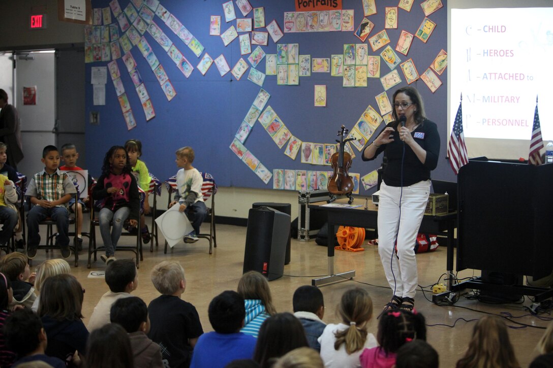 Debbie Fink signs the word “child” during a presentation at Zukeran Elementary School on Camp Foster April 23. Fink talked about her book, “Little C.H.A.M.P.S.: Child Heroes Attached to Military Personnel.” “I use American Sign Language for kinesthetic learners, and it holds their attention and keeps them busy,” said Fink. Fink, the co-author of C.H.A.M.P.S, visited the school during an Asia-Pacific tour with the USO. (U.S. Marine Corps photo by Cpl. Alyssa N. Gunton/ Released)
