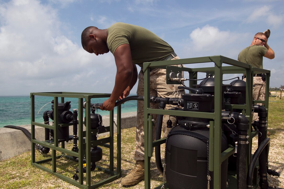 Pfc. James E. Baker connects a lightweight water purification system hose at Kin Blue beach near Camp Hansen April 30. The purpose of the training exercise was to train new Marines and test the functionality of the water purification systems for future use within the Asia-Pacific region, according to Sgt. Anthony W. Griggs. Baker and Griggs are water support technicians with Marine Wing Support Squadron 172, Marine Aircraft Group 36, 1st Marine Aircraft Wing, III Marine Expeditionary Force. 
