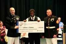 Chippewa Hills Senior Latear Dukes poses for a photo with Captain Matthew Carwile, Executive Officer of Recruiting Station Lansing, and Staff Sgt. Sean Whalen, a Recruiter with RSS Central Michigan, after receiving the Naval Reserve Officer Training Corps Scholarship, May 2. Dukes is one of only four Michigan natives who will receive the scholarship this year.