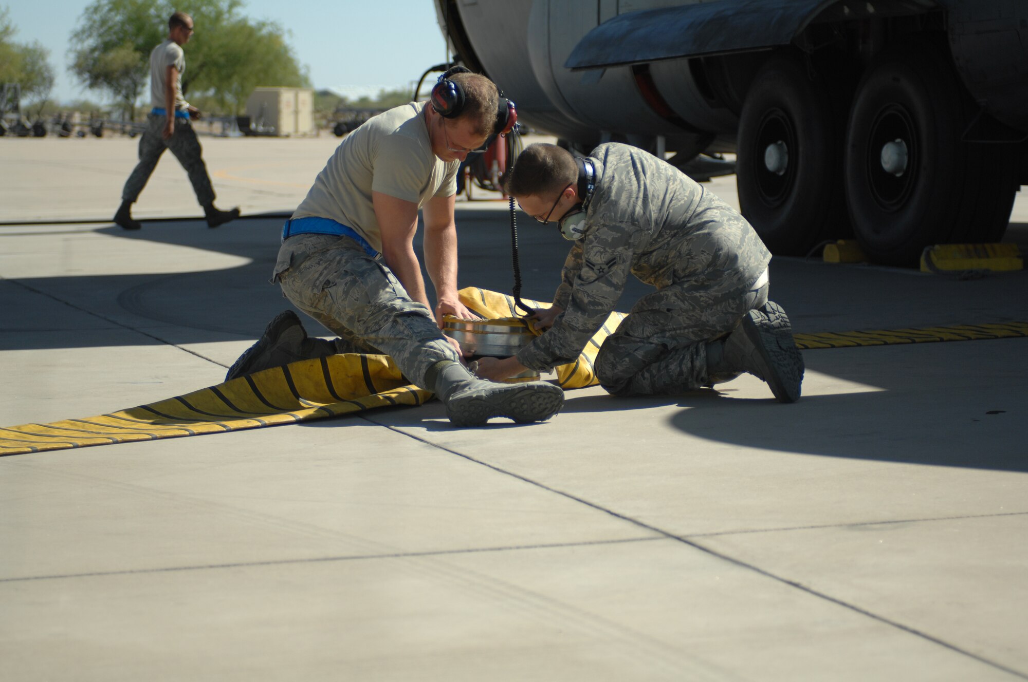 Airman 1st Class Daniel J. Boutwell and Corey B. Sweeny-Morehouse, 755th Aircraft Maintenance Squadron electronic warfare technicians, connect an air-conditioning hose to cool down an EC-130H Compass Call aircraft at Davis-Monthan Air Force Base, Ariz. May 1, 2013. The aircraft must maintain a cool temperature, so the computers in the back do not overheat.(U.S. Air Force photo by Airman 1st Class Betty R. Chevalier/released)