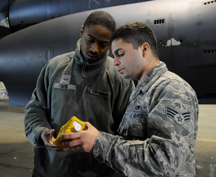 Airman 1st Class Andre Reid and Senior Airman Michael Mazzola, 2nd Maintenance Squadron Accessories Flight Fuels Maintenance, look over a photo-ionization detector on Barksdale Air Force Base, La., May 3, 2013. The PID is used by fuels maintenance Airmen while inside the fuel tanks to monitor the fuel vapor to oxygen ratio and ensure personnel have adequate oxygen. (U.S. Air Force photo/Airman 1st Class Andrew Moua)
