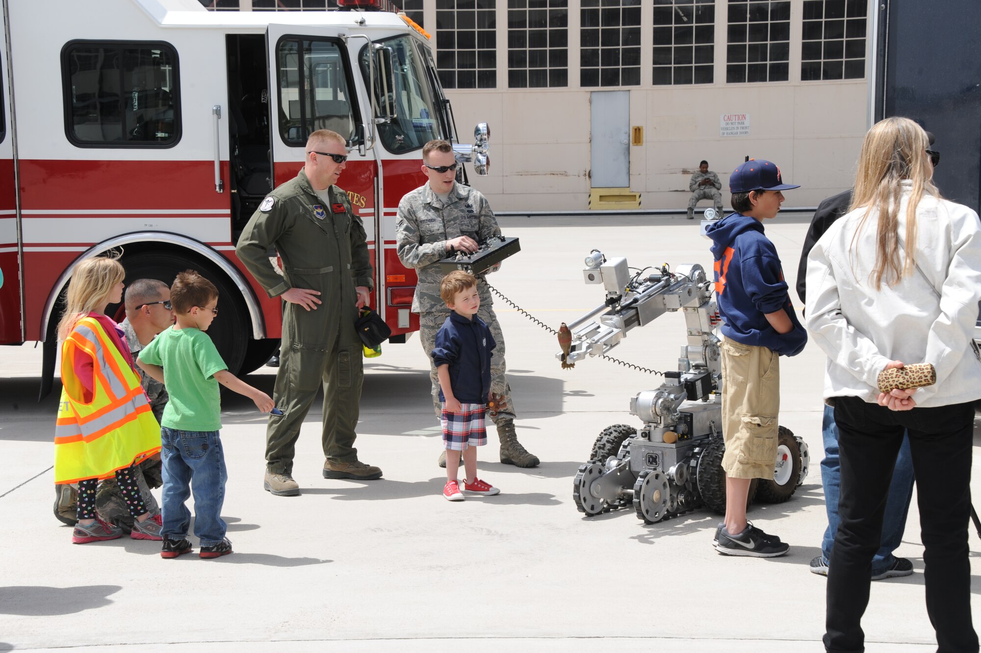 Airman 1st Class Davyd Fitzhugh,  377th Mission Support Group, gives a demonstration of the base’s F6 Explosive Ordnance Disposal robot. The remote control military robot can climb stairs and terrain at a 45-degree angle, and can lift up to 35 pounds.As part of “Take Our Daughters and Sons to Work Day,” employees were invited to bring their children to the base to learn more about Kirtland missions. (Photo by Todd Berenger)
