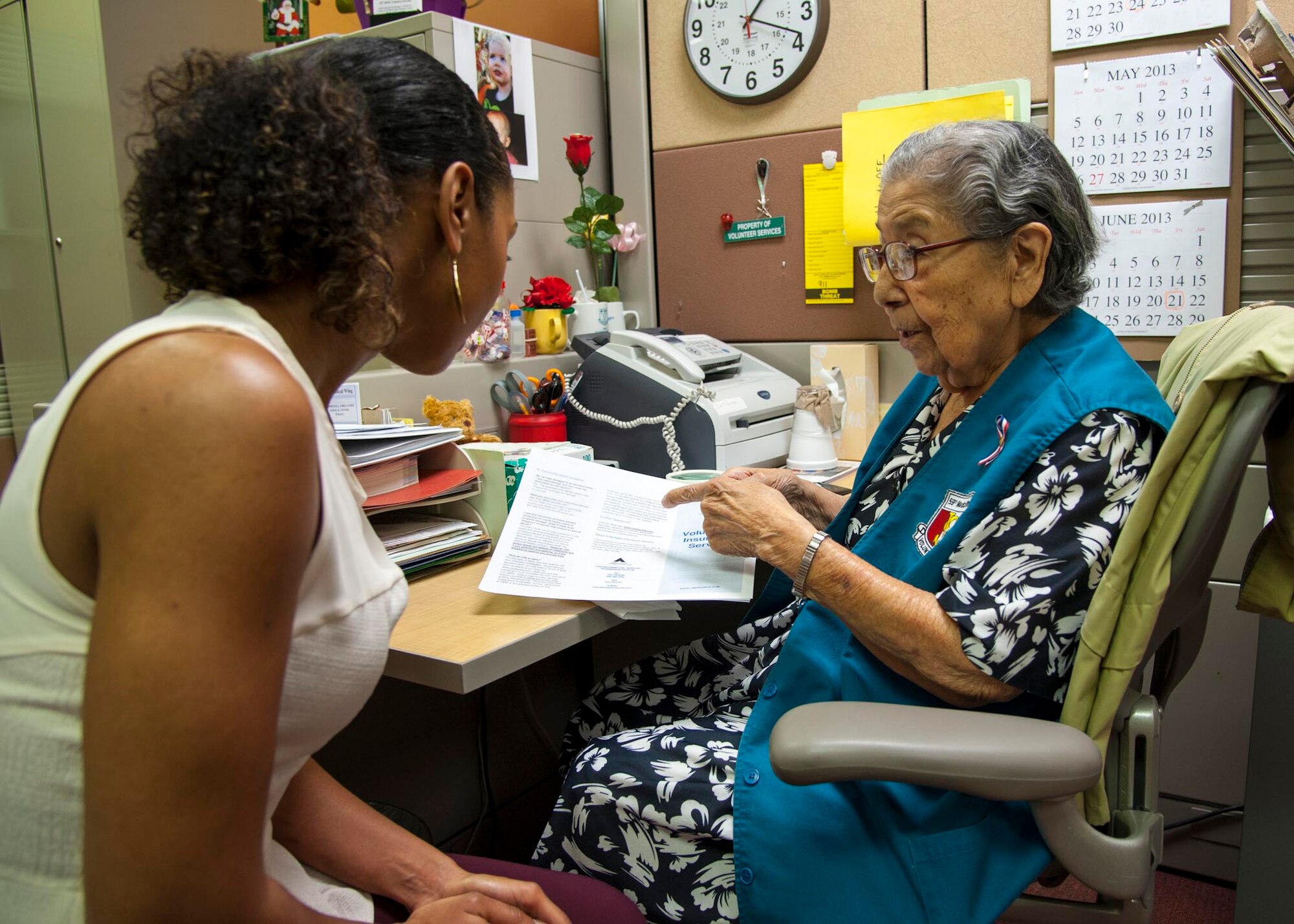 Trinidad Garcia explains insurance coverage for options for volunteers to Demetris Hardy April 16 at the Wilford Hall Ambulatory Surgical Center, Joint Base San Antonio-Lackland, Texas. Garcia has been a volunteer at the 59th Medical Wing for more than 20 years. Hardy is a WHASC credential specialist. Volunteers at the WHASC were recognized by Maj. Gen. Byron C. Hepburn, 59th MDW commander and director of the San Antonio Medical Health System, during a ceremony held April 24 as a part of National Volunteer Week. (U.S. Air Force photo/Staff Sgt. Kevin Iinuma)