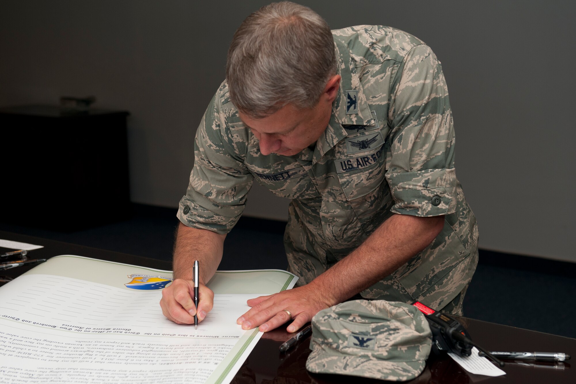 Colonel Kevin Bennett, 49th Mission Support Group commander, signs an oath at Holloman Air Force Base, N.M., May 3. Members pledged to either complete 30 hours of volunteer service or remain alcohol-free for 30 days from May 5 to June 6. This Alcohol Abstinence and Volunteerism Challenge hopes to increase community involvement and decrease the number of drunken driving incidents in the wing. (U.S. Air Force photo by Airman 1st Class Leah Murray/Released)