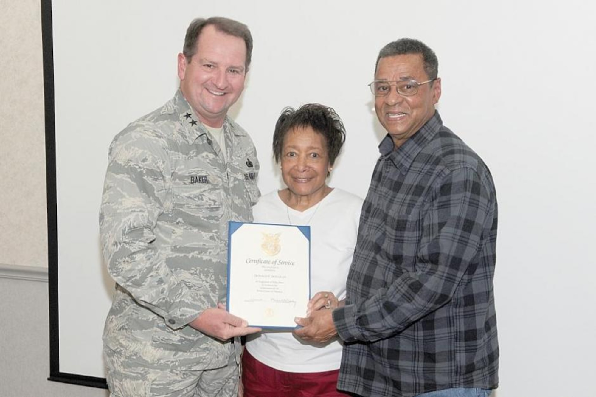 Maj. Gen. H. Brent Baker Sr., Ogden Air Logistics Complex commander, congratulates Donald and Mary Douglas, as Donald receives his 50-year certificate. (U.S. Air Force photo/Alex R. Lloyd)