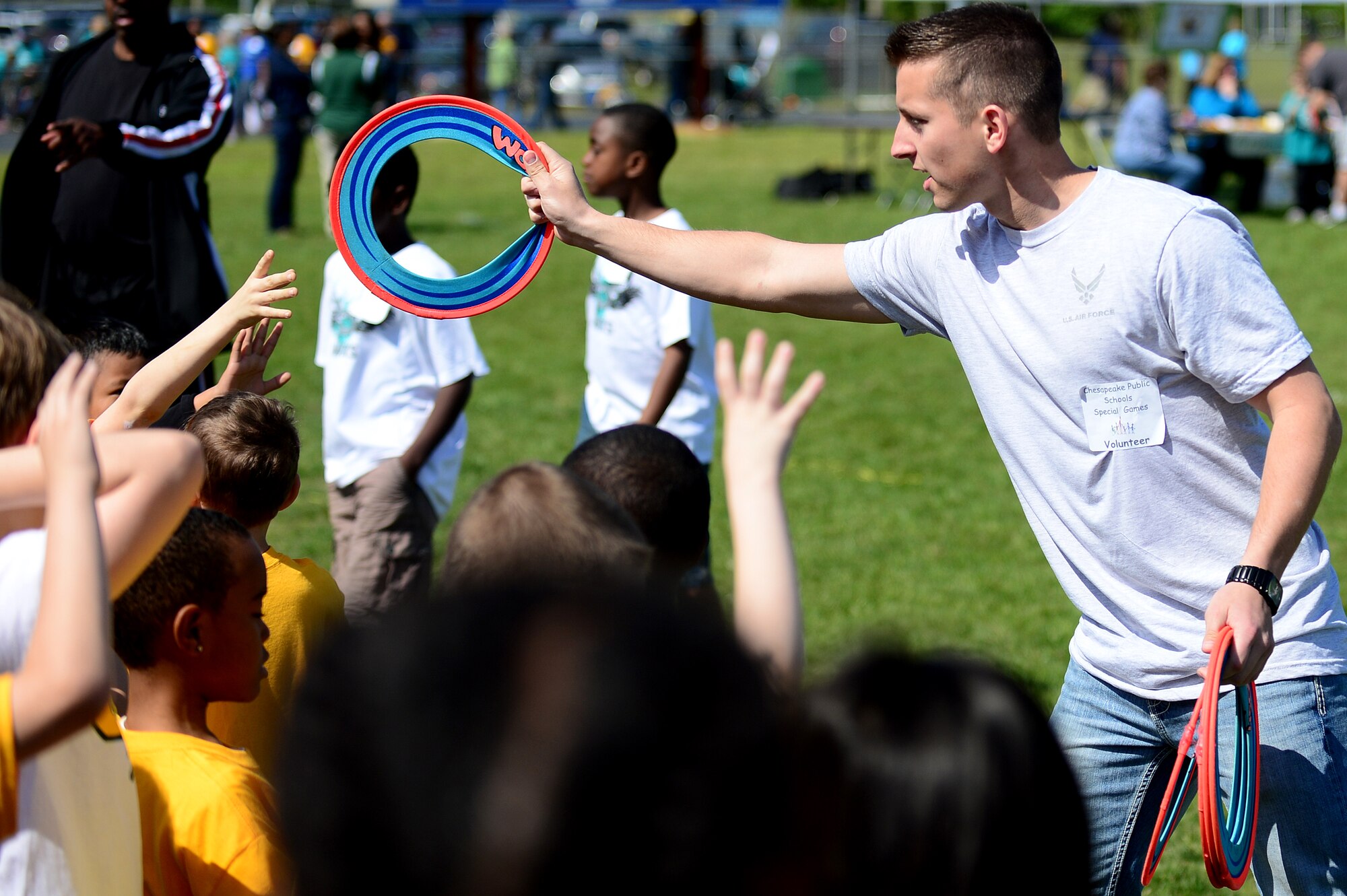 U.S. Air Force Senior Airman Kody Conley, 94th Air Maintenance Unit F-22 Raptor crew chief, passes Frisbee discs out to participants of the Special Games at Oscar Smith High School in Chesapeake, Va., April 26, 2013. Conley was part of the more than 100 Airmen from Langley Air Force Base that volunteered to assist the Special Games.  (U.S. Air Force photo by Senior Airman Kayla Newman/Released)